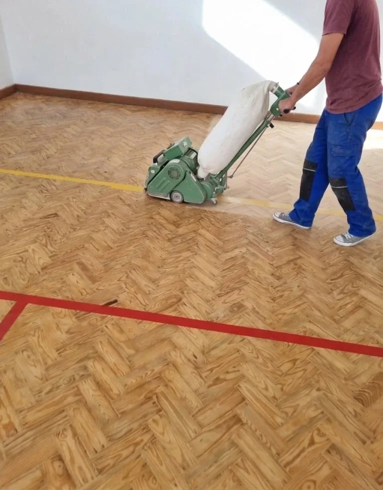 Afagamento de um piso de parquet em espinha com a afagadora de rolo