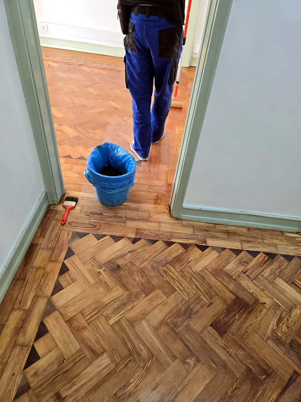 Corredor com parquet em espinha durante o envernizamento