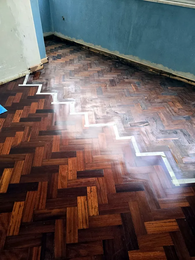 Parquet em espinha a meio do trabalho, com a divisão marcada a fita